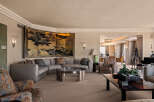 Step into this luxurious living room, featuring a grand sectional sofa adorned with decorative pillows and a striking gold-leaf screen art piece.