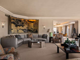 Step into this luxurious living room, featuring a grand sectional sofa adorned with decorative pillows and a striking gold-leaf screen art piece.