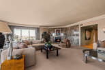 Experience luxury living in this spacious living room, featuring a grand marble fireplace and a comfortable sectional sofa perfect for gatherings.