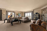 Experience luxurious living in this spacious living room, featuring a large sectional sofa and a plush armchair perfect for relaxation.