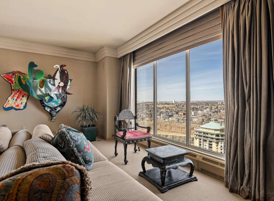Experience breathtaking panoramic city views from this stunning living room, featuring a large picture window that floods the space with natural light.