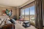 Experience breathtaking panoramic city views from this stunning living room, featuring a large picture window that floods the space with natural light.
