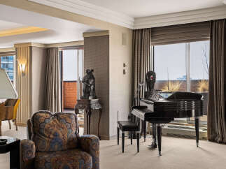 Experience luxury living in this elegant room featuring a grand piano and a comfortable armchair.