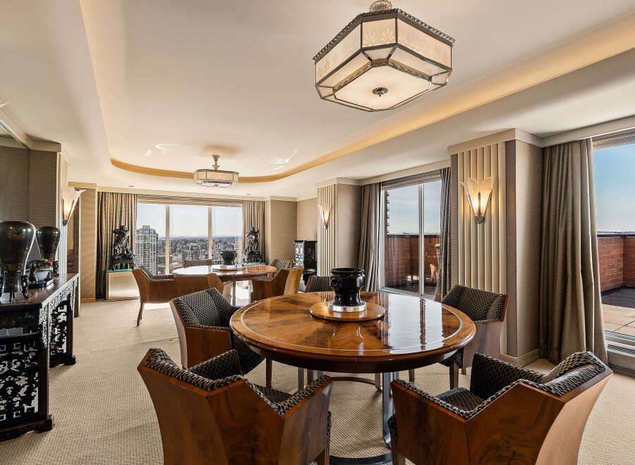 Experience luxurious living in this expansive dining area, featuring two elegant round dining tables perfect for hosting.