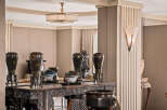 Experience refined living in this elegant space, featuring a stunning console table adorned with antique vases and intricate carvings.