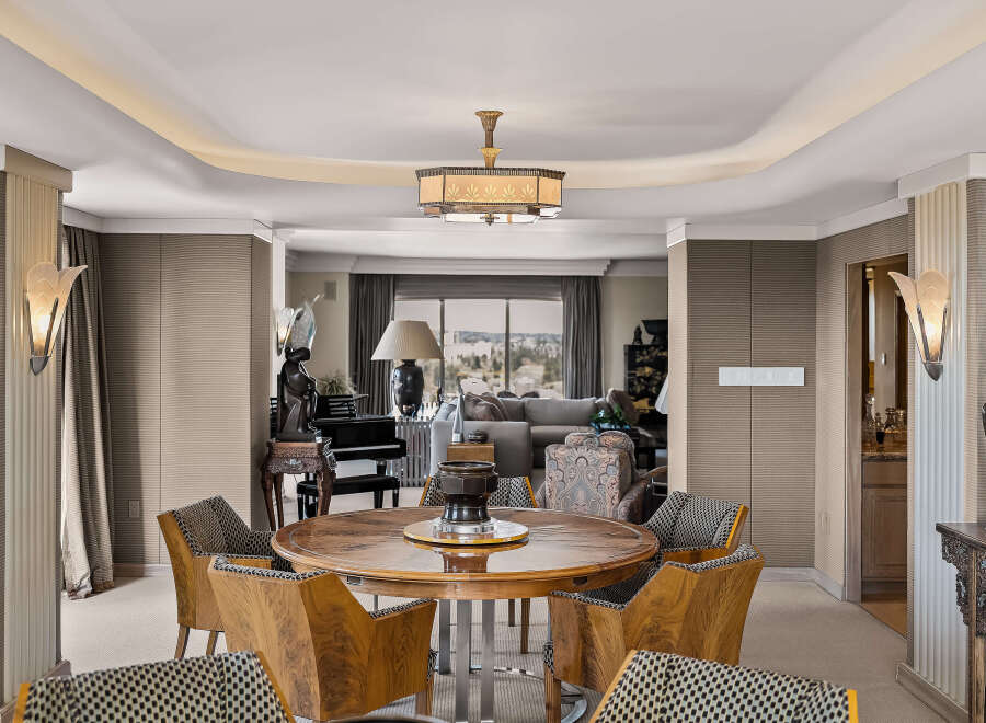 Experience elegant dining in this sophisticated space, featuring a stunning round wood table surrounded by uniquely designed chairs.