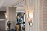 Illuminate your entryway with this exquisite Art Deco-inspired sconce, featuring frosted glass petals and polished chrome accents.