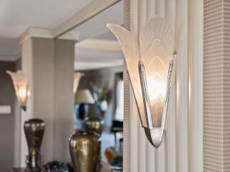 Illuminate your entryway with this exquisite Art Deco-inspired sconce, featuring frosted glass petals and polished chrome accents.