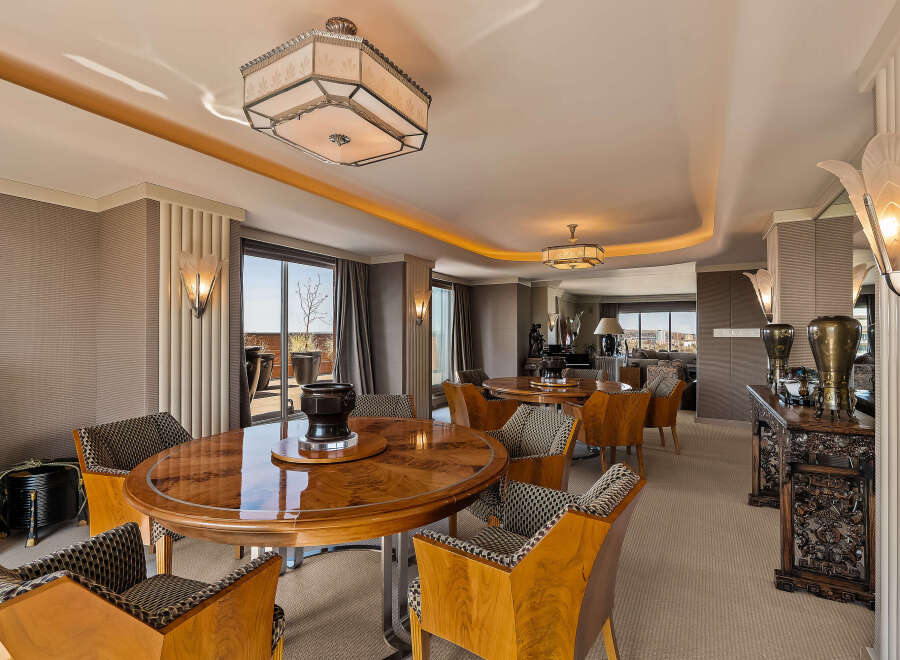 Experience luxurious dining in this elegant space, featuring a stunning art deco-inspired round dining table with matching chairs.