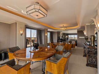 Experience luxurious dining in this elegant space, featuring a stunning art deco-inspired round dining table with matching chairs.