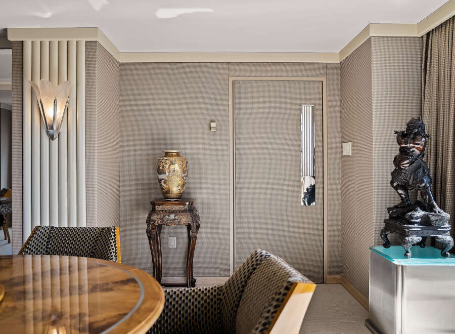 Step into a world of refined elegance with this stunning interior, featuring a striking art deco sconce that casts a warm glow.