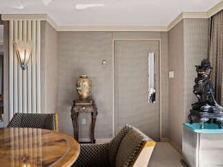 Step into a world of refined elegance with this stunning interior, featuring a striking art deco sconce that casts a warm glow.