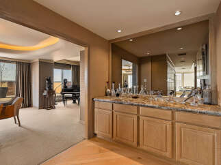Experience luxury living with this stunning property featuring a sophisticated bar area with a marble countertop and ample cabinetry, perfect for entertaining.