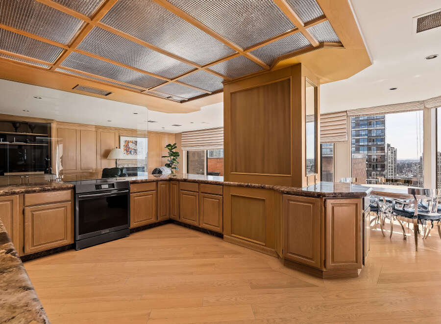 Experience luxury living in this stunning kitchen featuring elegant wood cabinetry and granite countertops.