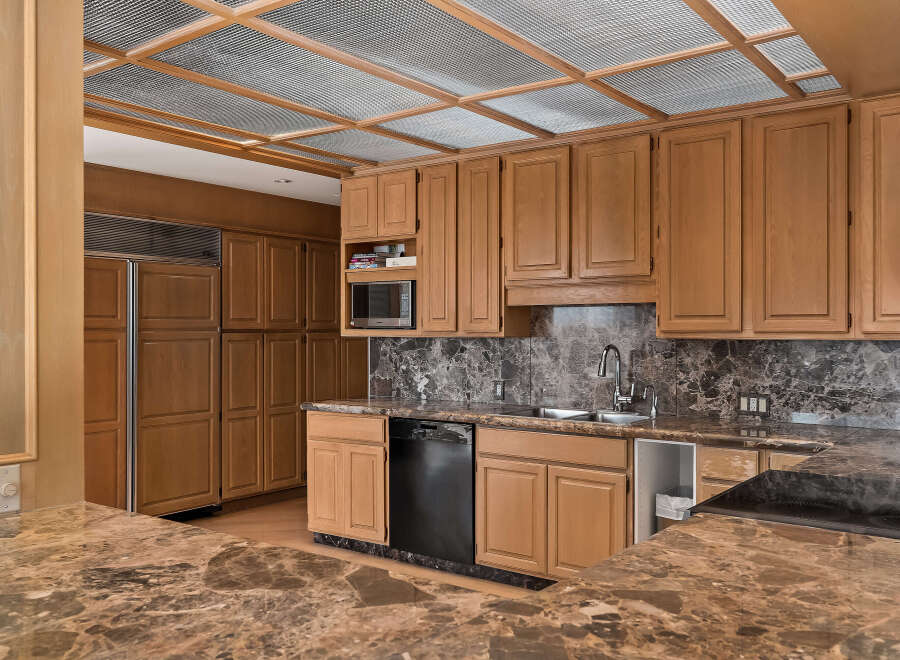 Discover this stunning kitchen featuring custom wood cabinetry and elegant marble countertops.