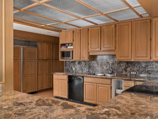 Discover this stunning kitchen featuring custom wood cabinetry and elegant marble countertops.