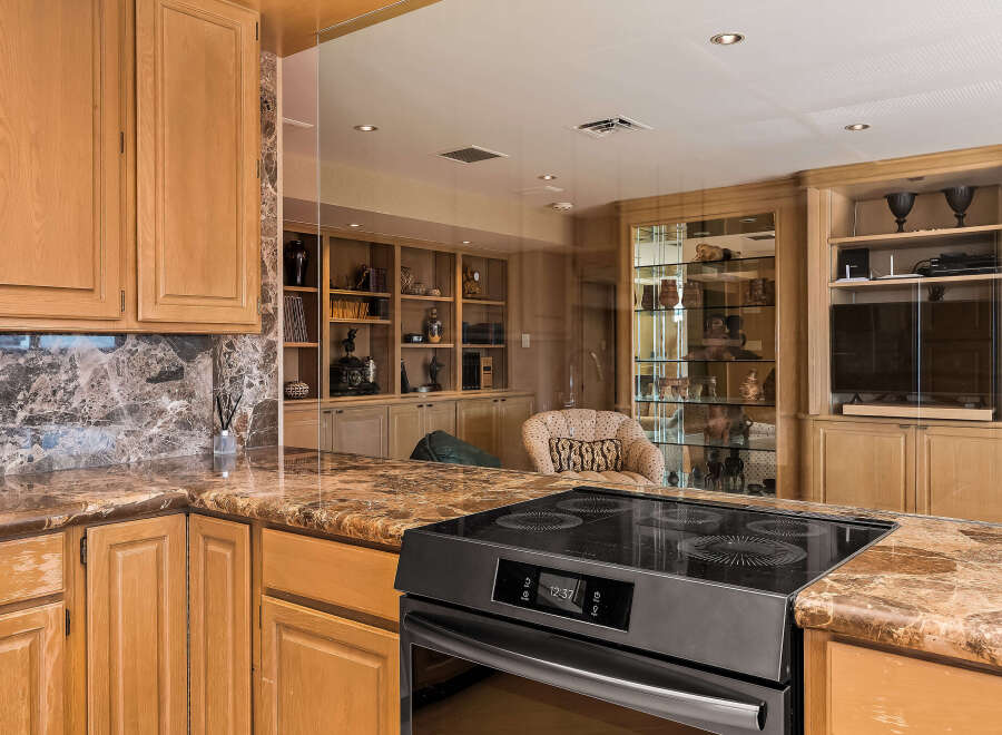 Experience luxury in this stunning kitchen featuring elegant marble countertops and custom wood cabinetry.