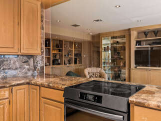 Experience luxury in this stunning kitchen featuring elegant marble countertops and custom wood cabinetry.