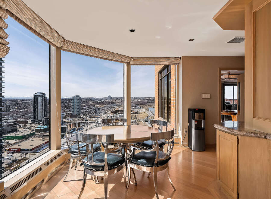 Enjoy breathtaking city views from this elegant dining area, featuring a round table with sleek, modern chairs.