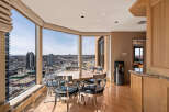 Enjoy breathtaking city views from this elegant dining area, featuring a round table with sleek, modern chairs.