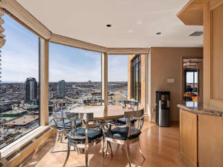 Enjoy breathtaking city views from this elegant dining area, featuring a round table with sleek, modern chairs.