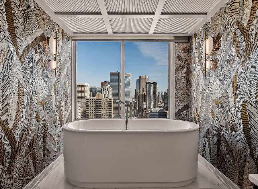 Experience luxury in this stunning bathroom featuring a freestanding soaking tub with breathtaking city views.
