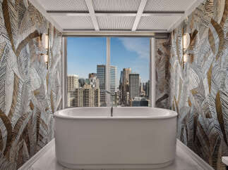 Experience luxury in this stunning bathroom featuring a freestanding soaking tub with breathtaking city views.