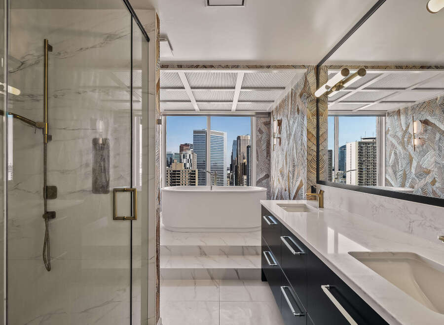 Experience luxury in this stunning bathroom featuring a freestanding soaking tub with breathtaking city views.
