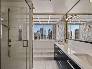 Experience luxury in this stunning bathroom featuring a freestanding soaking tub with breathtaking city views.