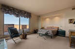 Experience luxurious living in this stunning bedroom featuring a king-sized bed with a vibrant, patterned comforter.