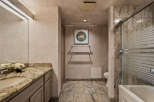 Experience luxury in this elegant bathroom featuring a granite-topped vanity with a vessel sink and a spacious shower-tub combination with frosted glass doors.