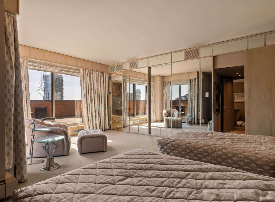 Experience luxurious city living in this spacious master suite, featuring two plush beds and a private balcony with stunning city views.