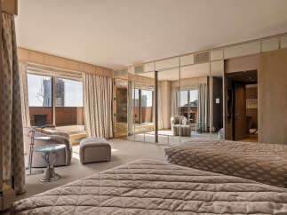 Experience luxurious city living in this spacious master suite, featuring two plush beds and a private balcony with stunning city views.