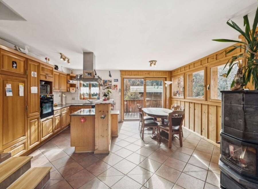 This charming kitchen boasts warm wooden cabinetry and a spacious island, perfect for meal preparation and casual dining.