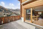 Experience breathtaking mountain views from this charming wooden chalet's balcony, perfect for enjoying crisp alpine air.