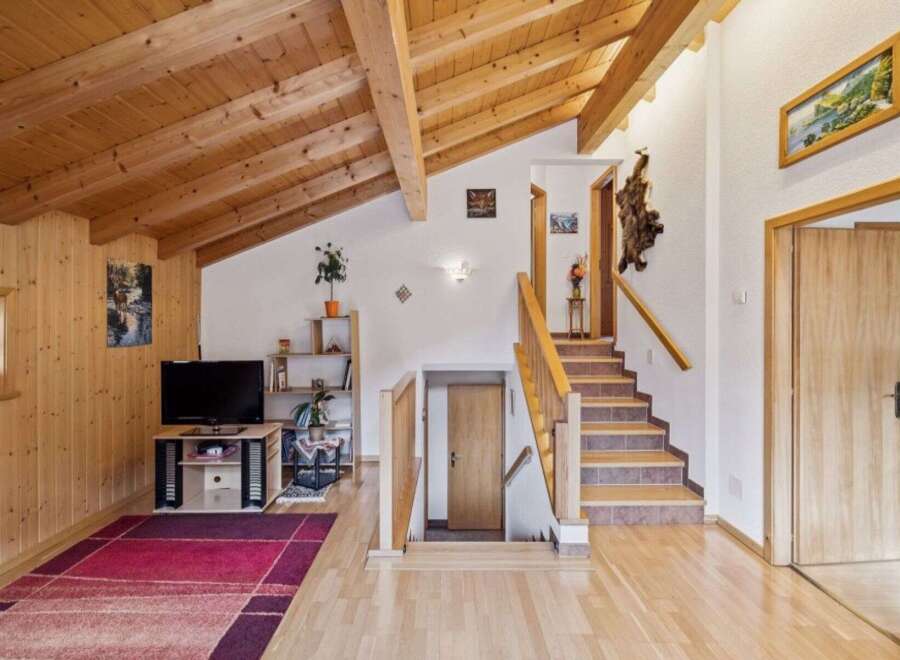 Experience rustic charm in this inviting home featuring a stunning wood-paneled ceiling and walls, creating a warm and cozy atmosphere.