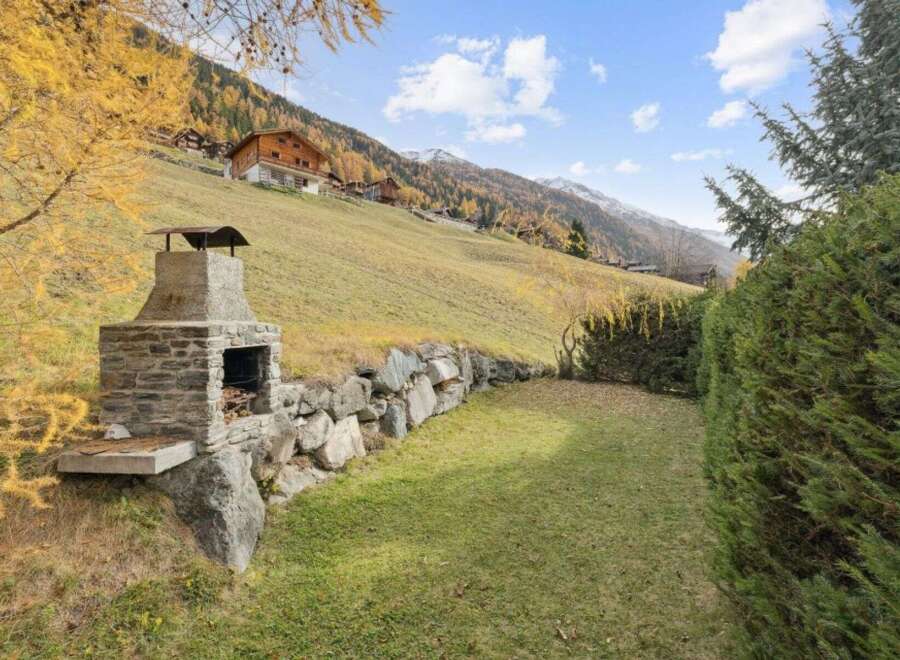 Experience the charm of alpine living with this stunning property, featuring a rustic stone barbecue area perfect for outdoor entertaining.