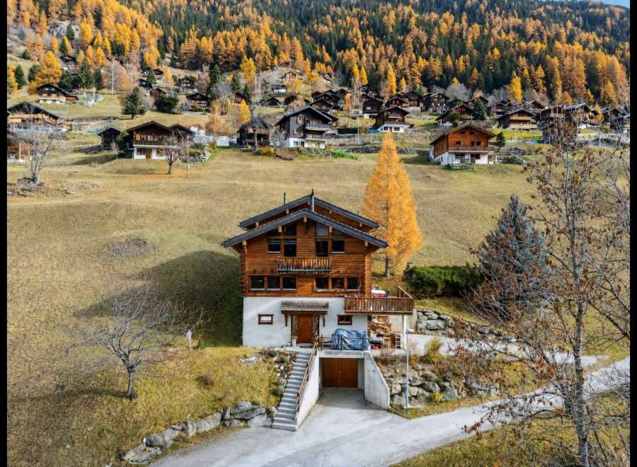 Nestled amidst the vibrant autumn foliage of the Swiss Alps, this charming wooden chalet offers a picturesque retreat.