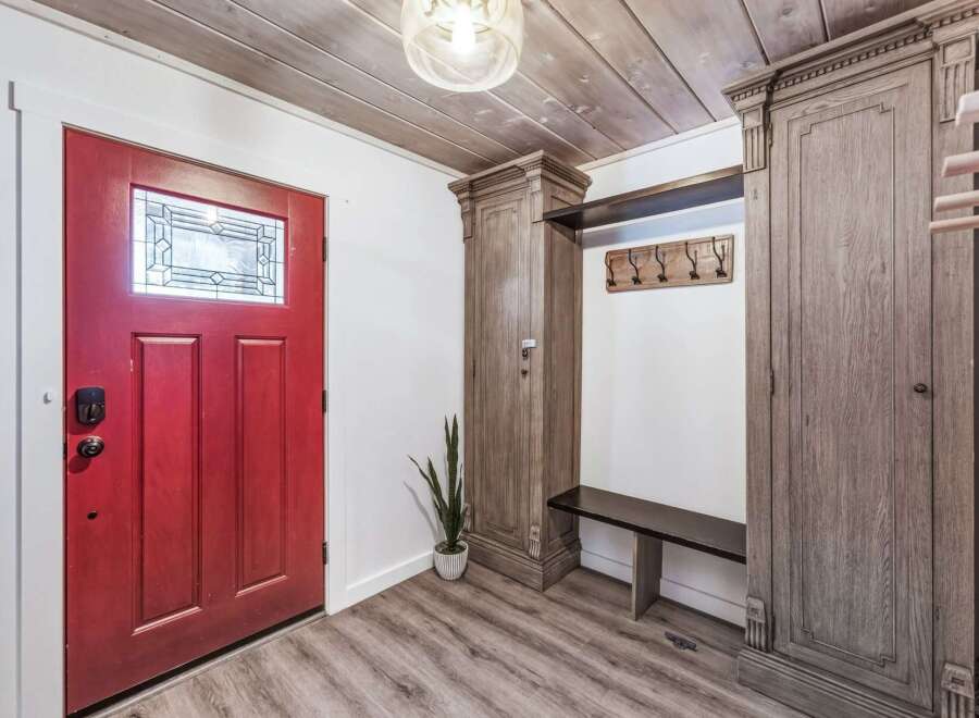 Step into this inviting entryway featuring a vibrant red door with decorative glass, setting a warm and welcoming tone.