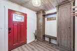 Step into this inviting entryway featuring a vibrant red door with decorative glass, setting a warm and welcoming tone.