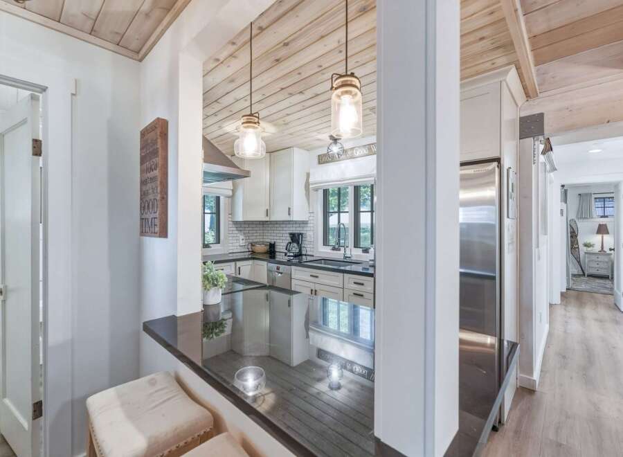 Experience coastal charm in this beautifully renovated kitchen, featuring crisp white cabinetry, subway tile backsplash, and sleek black countertops.