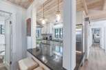 Experience coastal charm in this beautifully renovated kitchen, featuring crisp white cabinetry, subway tile backsplash, and sleek black countertops.