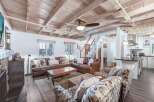 Experience rustic charm in this inviting living space, featuring a cozy leather sectional and plush accent chairs perfect for relaxation.