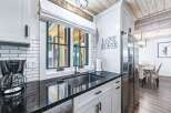Experience the charm of this lakeside retreat, featuring a modern kitchen with sleek black countertops and white cabinetry.