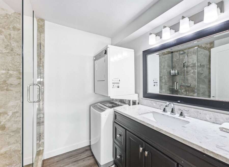 This modern bathroom features a stacked washer and dryer for ultimate convenience, perfect for busy households.