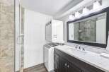 This modern bathroom features a stacked washer and dryer for ultimate convenience, perfect for busy households.
