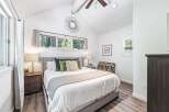 Experience serene living in this charming bedroom, featuring a comfortable queen-size bed adorned with plush pillows and a cozy throw.