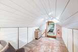 Discover this charming attic bedroom, featuring a vaulted shiplap ceiling and ample built-in storage.