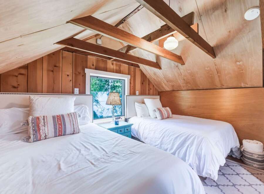 Discover this charming attic bedroom featuring two cozy beds, perfect for accommodating guests.