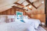 Discover this charming attic bedroom featuring two cozy beds, perfect for accommodating guests.